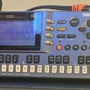 Stříbrný sekvencer s modrým displejem a ovládacími prvky. Na horní straně je nápis DY22 MUSIC SEQUENCER, logo midi a značka YAMAHA. Zařízení obsahuje…