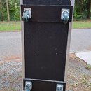 Černý transportní flightcase s hliníkovými hranami a kovovými rohy. Na horní a spodní straně jsou připevněny čtyři otočná kolečka s kovovými držáky.…