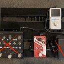 Černý kovový pedalboard s třemi efekty. Vlevo je černý přístroj s nápisy PROFILER a KEMPER, vpravo nahoře bílý pedál s nápisy polytune 3 TRUE BYPASS…