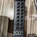 Černý rackový stagebox s osmi XLR výstupy označenými jako OUT 1 až OUT 8. Na zařízení je uveden nápis MIDAS a model DL8. Spodní panel obsahuje dva ko…
