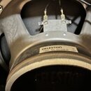 Detailní pohled na zadní část reproduktoru se stříbrným kovovým rámem. Na rámu je nalepený bílý štítek s nápisy CELESTION, G12K60 a R21 VINTAGE 80 11…