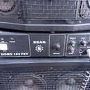 Černý kytarový zesilovač s nápisy SEAK a MONO 103 FET. Přední panel obsahuje ovládací prvky MASTER, TREBLE, BASS a tři potenciometry GAIN 1, GAIN 2,…