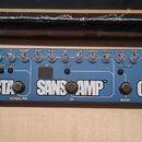 Modrý kytarový efektový pedalboard s nápisy BASS FLY RIG a TECH 21. Zařízení obsahuje čtyři sekce s nápisy CHR, OCTA, SANSAMP a COMPO, každá s vlastn…