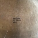 Detailní pohled na povrch mosazného činele s viditelným broušením. Uprostřed je černý nápis Emotion 20"/50cm Ride. Povrch vykazuje drobné škrábance a…