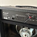 Zadní panel kytarového komba značky Marshall, model AV15BX. Černý povrch je potažen texturovaným vinylen. Na panelu jsou nápisy Marshall, Designed by…