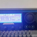 Černý rackový procesor s nápisy TC HELICON a VOICELIVE RACK. Zařízení má modrý displej s textem BRIGHT DOUBLE, PRESET 5, STEP 1, COUNT 1 a MIC-CONTRO…