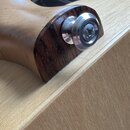 Detailní záběr na konec hmatníku a hlavu strunového nástroje z tmavého dřeva. Na konci hmatníku je osazen kovový kolík s imbusovou hlavou a nápisem "…