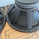Detailní pohled na dva černé reproduktory s kovovými rámy. Na pravém reproduktoru je vidět bílý štítek s označením G7580441 a připojovací svorky. Rep…