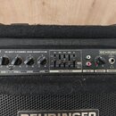 Černý basový kombozesilovač značky BEHRINGER, model BXL450. Na ovládacím panelu je nápis 45-WATT 2-CHANNEL BASS WORKSTATION a FBQ EQUALIZER s pětipás…
