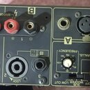Zadní panel černého audio zesilovače s hliníkovým chladičem. Jsou zde viditelné nápisy BRIDGE, SPEAKERS, INPUT a značka YSProcessing. Zařízení obsahu…