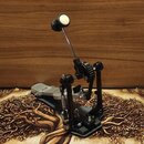 Jedný pedál basového bubnu s černou základnou a stříbrným šlapadlem. Mechanismus pohonu je řešen pomocí černého řetězu a kovové hůlky s bílo-černým k…