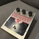 Efektový pedál v hliníkovém šasi s nápisem BIG MUFF a logem pínače. Na horní části jsou tři černé ovládací knoflíky s popisky VOLUME, TONE a SUSTAIN.…