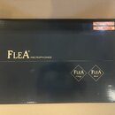 Černá papírová krabice s nápisem FLEA® MICROPHONES. V pravé dolní části jsou dvě kosočtvercová loga s nápisy FLEA Vintage a FLEA Next. V pravém horní…