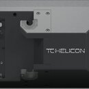Zadní strana černého elektronického zařízení značky TC HELICON. V levé části se nachází panel s konektory MIC, GUITAR, SWITCH, AUX/KEYS, OUT, MIDI a…
