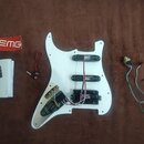 Bílý plastový pickguard pro elektrickou kytaru s instalovanými třemi černými snímači. Na snímačích je vidět nápis EMG. Součástí je bílý papírový manu…