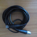 Černý svinutý kabel s konektory na obou koncích. Jeden konektor je v provedení USB, druhý je cylindrický s kovovou zakončenou částí. Na kabelu nejsou…