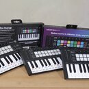 Tři černé MIDI kontroléry s klávesami a barevnými pady, umístěné před dvěma původními krabicemi. Na zařízeních i na obalech je vidět nápis LAUNCHKEY…