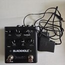 Černý kytarový efekt s nápisy BLACKHOLE a Eventide. Zařízení má šest ovládacích knoflíků s popisky Mix, Gravity Delay, Feedback Q, Size Depth, L.O Ra…