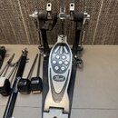 Černý basový pedál s kovovými prvky a logem Pearl na šlapadle. Nástroj vykazuje známky používání v podobě oděraného povrchu a znečištění kovových čás…
