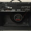 Zadní strana černého kytarového komba s odstraněným zadním krytem. Na horním štítku jsou nápisy Roland, MODEL: KT-100, MADE IN MALAYSIA a sériové čís…