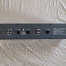 Zadní strana černého elektronického zařízení s řadou konektorů. Na panelu jsou nápisy BAL / UNBAL INPUT, UNBAL IN, UNBAL OUT, BAL / UNBAL OUTPUT a oz…