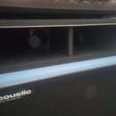 Detailní pohled na černý reproduktor s nápisem acoustic a pod ním menším textem MODEL 408 TRANSDUCER. Přední strana je kryta černou textilní mřížkou,…
