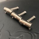 Kovové příslušenství tvořené jednou hlavní lištou a třemi šroubovacími mechanismy. Povrch je nerezový s jemným leskem. Na součástkách nejsou žádné vi…