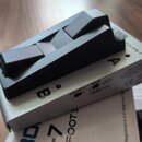 Stříbrný nožní spínač s černým plastovým pedalem. Na boku jsou nápisy POLARITY, MODE, FS-5U MOMENTARY a FS-5L LATCH, doprovázené přepínači a písmeny…