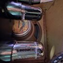 Detailní pohled do vnitřku přístroje, kde jsou vidět dvě elektronky s kovovými kryty. Mezi nimi je umístěn reproduktor s nápisem WAREHOUSE Guitar Spe…