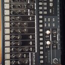 Černý drum machine v dřevěném rámu s nápisem DRUMBRUTE Nova Drum Machine a logem ARTURIA. Zařízení obsahuje řadu otočných potenciometrů, tlačítek a p…