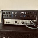 Zadní strana černého kytarového komba značky Hughes & Kettner. Na zadním panelu jsou nápisy FX LOOP, FOOTSWITCH, RED BOX a SPEAKER 8-16 Ohms, dále lo…