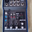 Kompaktní mixážní pult s modrým kovovým rámem a šedým předním panelem. Na horní části jsou nápisy kaifat, ME502 a PREMIUM 5-INPUT 2-BUS MIXER. Zaříze…