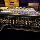 Černý digitální mixážní pult značky PreSonus s modře podsvícenými faderovými čápky. Na zadním panelu jsou vidět vstupy s nápisy Mic +48V, Talkback Mi…