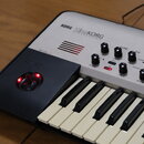Stříbro-černý syntetizátor s klávesnicí. Na horním panelu je nápis KORG KingKORG SYNTHESIZER a řada ovládacích knoflíků s popisky jako TUBE, EQ, PRE…