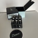 Černý kytarový efekt s nápisem Dream 65 REVERB-AMP. Zařízení má pět ovládacích knoflíků, dva zapínací spínače a čtyři konektory s popisky 1/MONO, IN,…