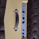 Kytarový zesilovač s béžovým potahem a hnědým koženým úchytem. Na stříbrném ovládacím panelu jsou nápisy MIC, INSTRUMENTS, MIC VOL, LO GAIN, INST.VOL…