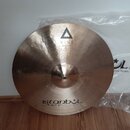 Kruhový mosazný činel s viditelným broušením povrchu. Na horní části je černý trojúhelník a nápis XIST, ve spodní části nápisy istanbul Agop Made in…