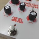 Bílý efekt pedál s červenými prvky a nápisy. Na horní straně jsou čtyři černé ovládací knoflíky s kovovými vršky a popisky FILTER, FUZZ, RESON a LEVE…