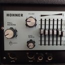 Detail ovládacího panelu zesilovače značky HOHNER. Panel obsahuje otočné knoflíky s popisky VOLUME, HALL REVERB a ECHO REVERB, posuvníky ekvalizéru s…