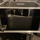 Černý transportní flightcase s hliníkovými hranami a vrchním víkem. Na horní části je nalepený černobílý štít s nápisem "DREAMCATCHER". Vnitřní prost…