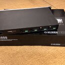 Černý rackový procesor značky KLARK TEKNIK, model DF1000. Na předním panelu jsou vidět konektory XLR a jack, nápisy LINE LEVEL, OUTPUTS a INPUTS. Zař…
