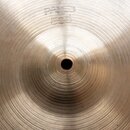 Detailní pohled na střed mosazného činele s viditelným koncentrickým broušením povrchu. V horní části je vyražen nápis PAISTE a pod ním číslo 505. Vp…
