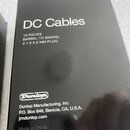 Černá krabice s bílými nápisy. Na horní části je text DC Cables a specifikace 10 PIECES BARREL TO BARREL 2.1 X 5.5 MM PLUG. Ve spodní části je logo D…