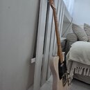 Elektrická kytara s přírodním dřevěným povrchem těla a hmatníku. Nástroj má černý pickguard, dva snímače a stříbrný hardware. Povrch těla vykazuje hr…
