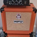Černý kytarový zesilovač s nápisy Peavey a 6505 PIRANHA™ stojí na dvou oranžových reproduktorových boxech značky ORANGE. Zesilovač má ovládací prvky…