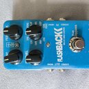 Modrý efekt pedál s nápisy FLASHBACK, DELAY AND LOOPER a tc electronic. Zařízení má čtyři černé ovládací knofíky, stříbrný spínač a několik vstupů a…