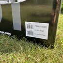 Detailní záběr na černý, lesklý povrch krabice s bílou nálepkou. Na nálepce je uveden text ITEM17710301, KS 14X5.75 SDB a Snare Drum 14"x5.75", Brass…