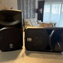 Dva černé aktivní reproduktory značky Yamaha. Na spodní části stojícího a na levé straně ležícího reproduktoru je bílé logo Yamaha s nápisem YAMAHA.…