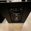 Zadní panel černého reproduktoru s ovládacím panelem. Jsou zde nápisy VOLUME, INPUT RIGHT, CLIP RIGHT, CLIP LEFT a INPUT LEFT, dvě červené kontrolky…
