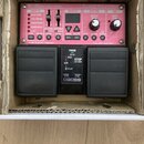Černý efekt pedál Boss RC-30 Loop Station s červeným předním panelem a dvěma velkými stoupacími spínači. Na panelu jsou nápisy RC-30 DUAL TRACK LOOPE…